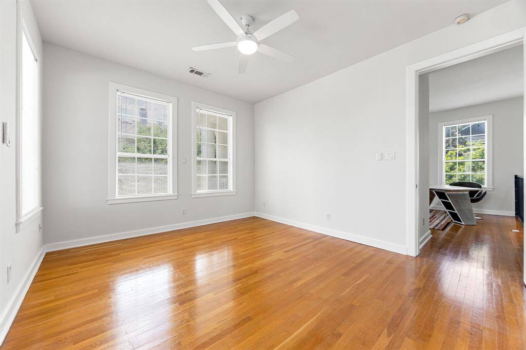 This spacious upstairs secondary bedroom is bathed in natural light, thanks to its large windows.