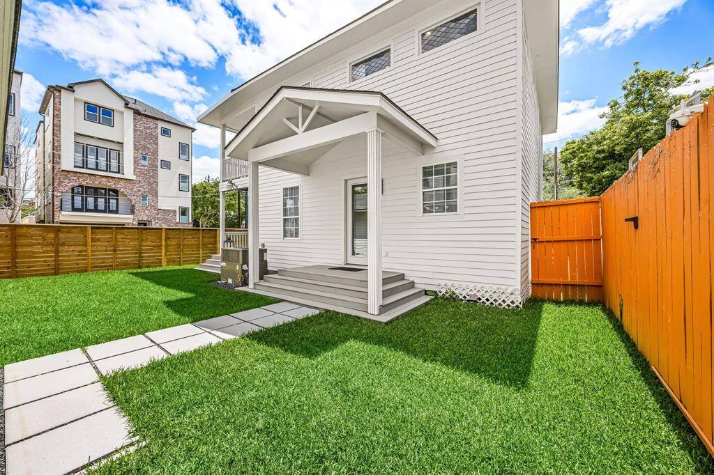View of the covered back door and porch of the home. Plenty of space to design your own outdoor kitchen and/or space for your pets to roam.