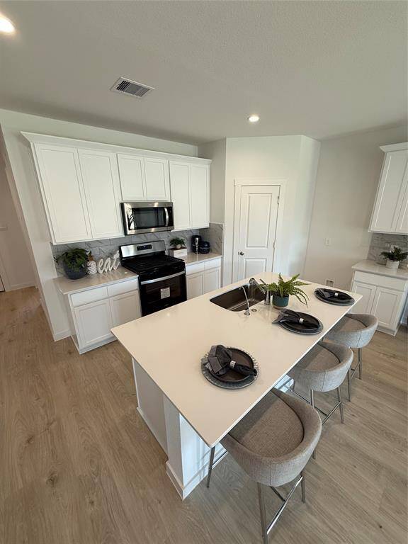 Sleek granite countertops and modern stainless steel appliances, including a refrigerator.