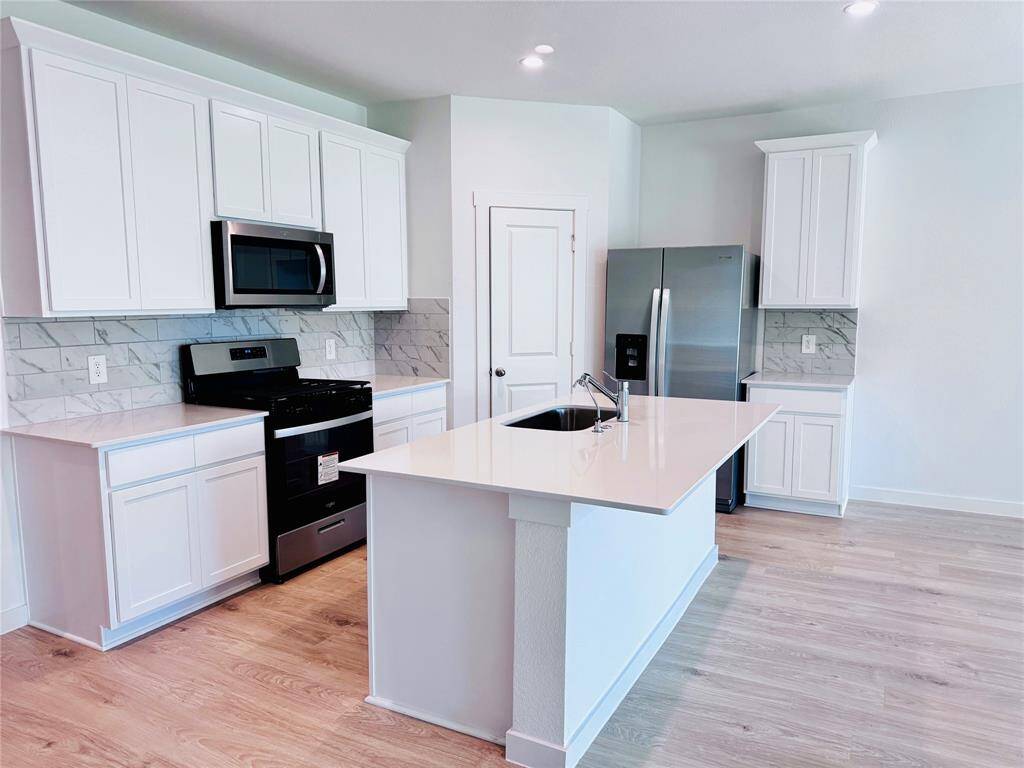 Luxurious granite countertops and sleek stainless steel appliances, including a refrigerator.