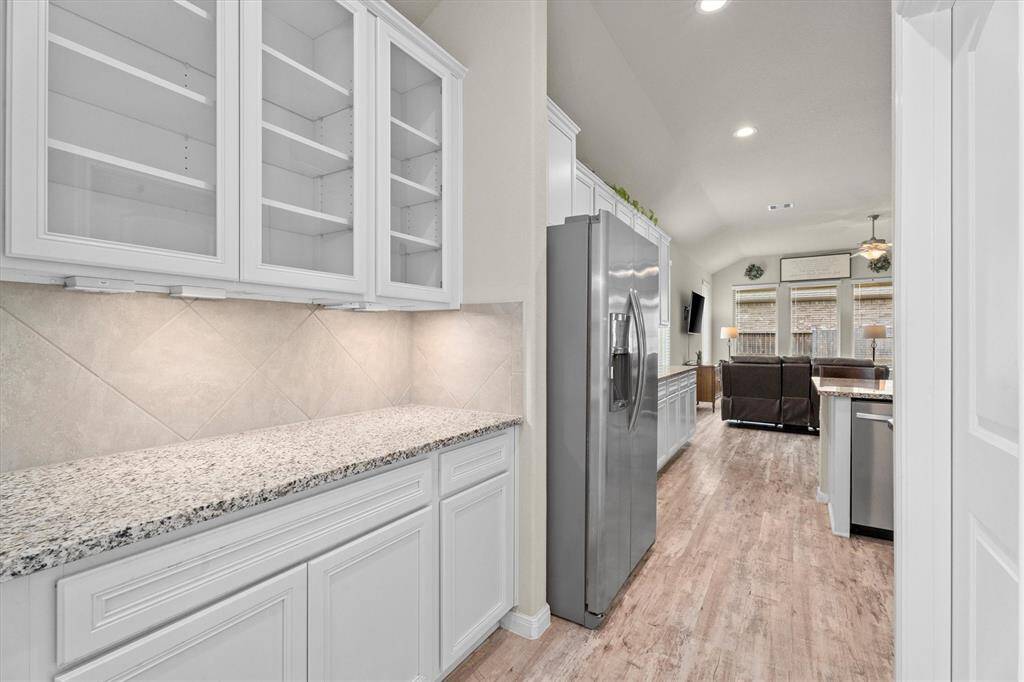 This elegant butler's pantry seamlessly links the dining area and kitchen. Additional storage is conveniently located through the door on the right side.