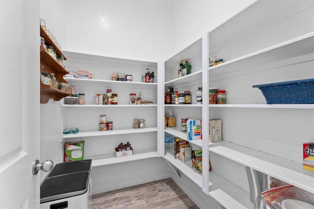 Across from the butler's pantry, there's an expansive walk-in pantry with abundant shelving for effortless organization.
