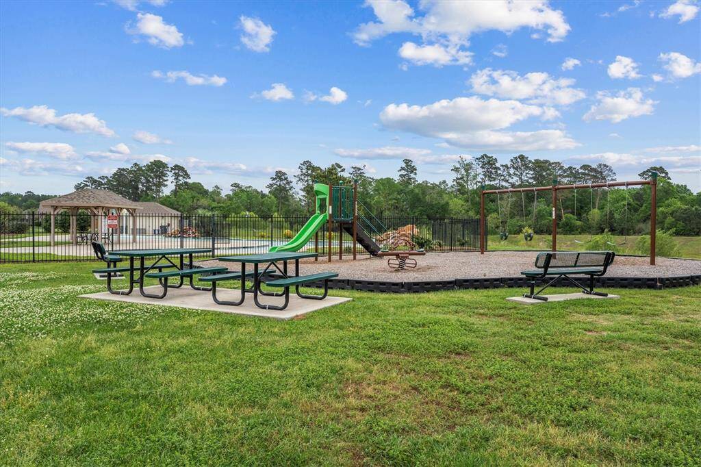 A playground and picnic area adjacent to the community pool.