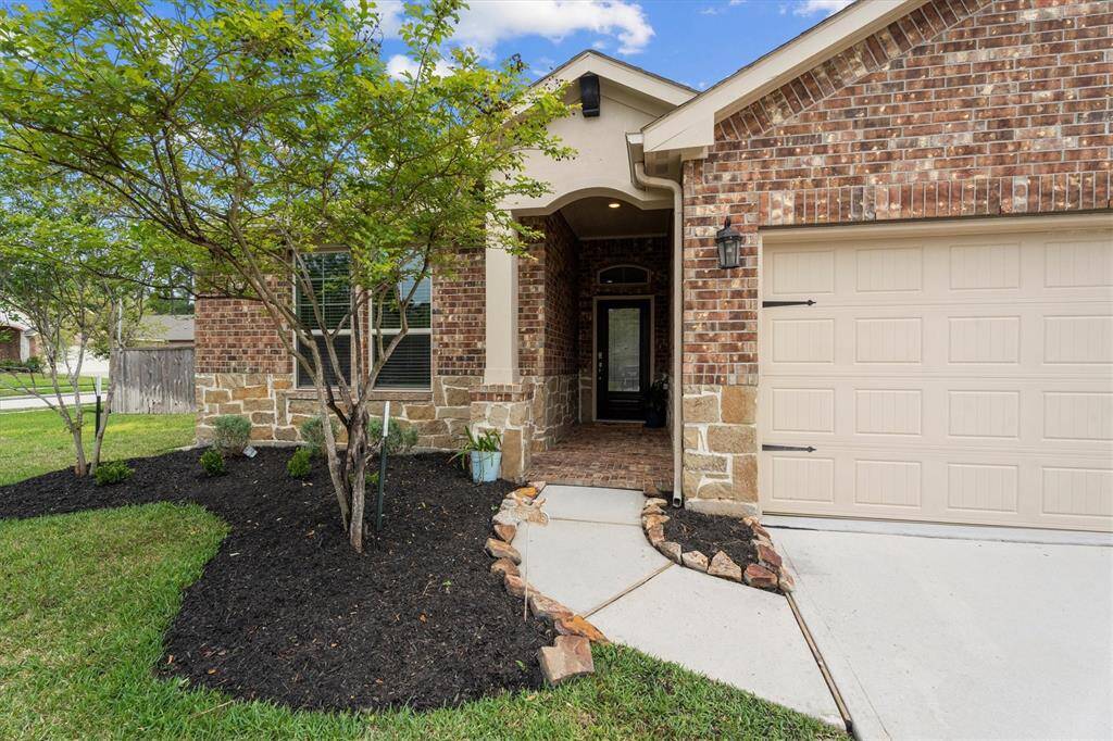 Freshly mulched flower beds welcome you onto a cozy, front porch.