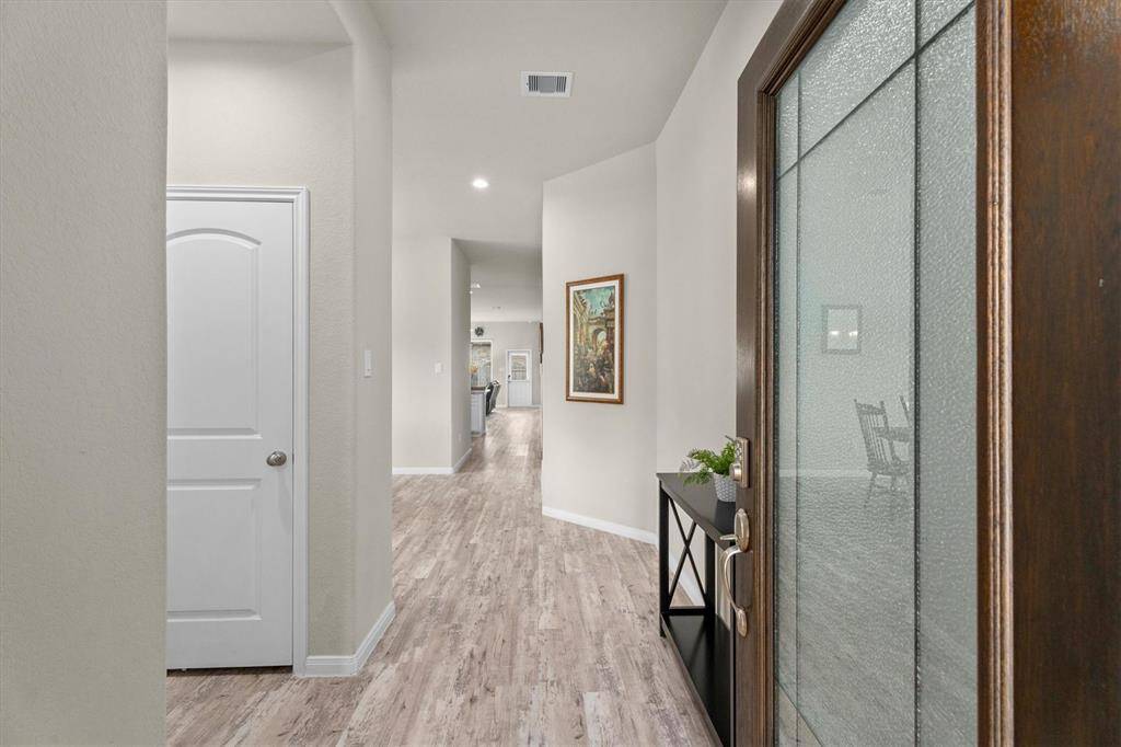 As you enter the warm tones of the vinyl flooring draw your eye all the way to the back of the home.