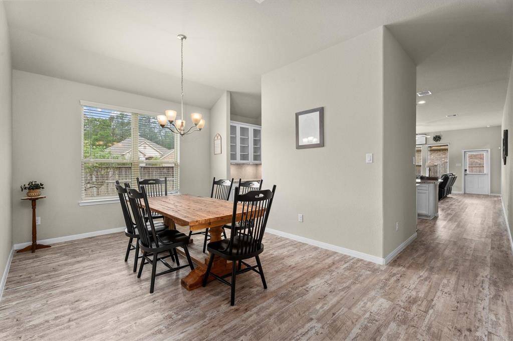 Spacious dining area with abundant natural light from a large window. Enjoy views of the elegant glass-doored cabinets in the butler’s pantry.