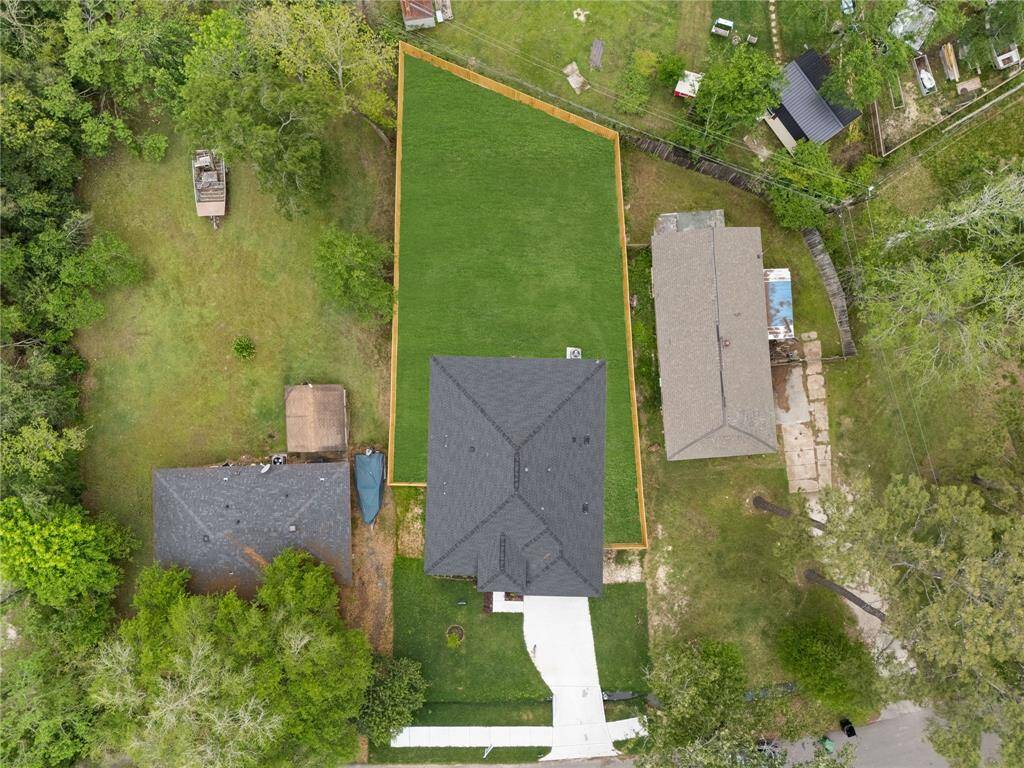 This stunning aerial shot captures the home in its entirety, highlighting the spacious yard surrounded by a newly installed privacy fence.