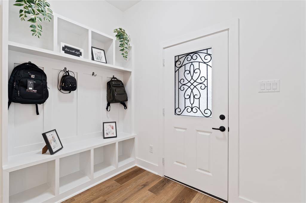 The entry way is complete with well-organized mud area with modern storage solutions, featuring a built-in bench and hooks for convenience.