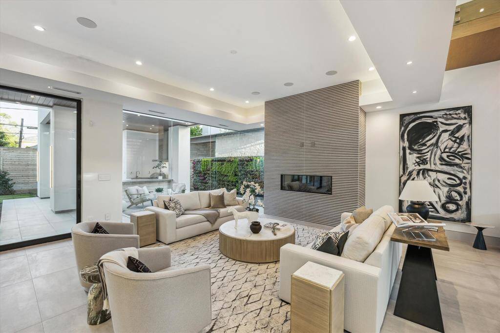Living room with tray ceiling and cove lighting with fireplace with Porcelanosa tile surround