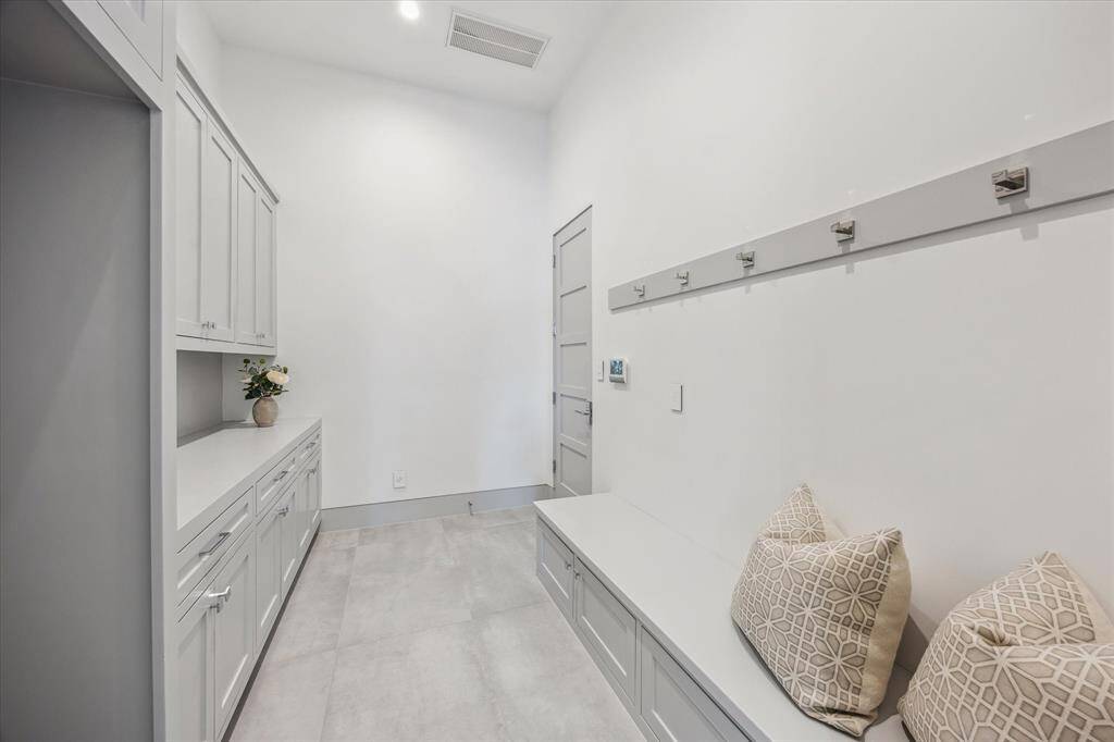 Mud room with storage and space for additional refrigerator.  Entry to three car tandem garage and EV charging
