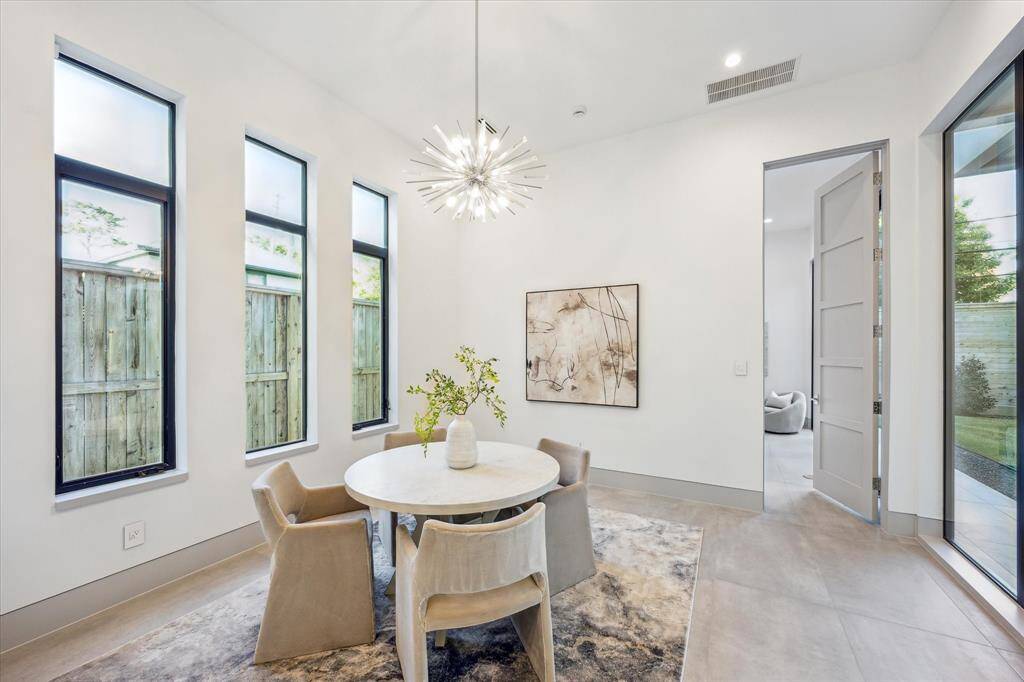 Breakfast room with built in buffet with storage and custom lighting. Door to downstairs guest bedroom