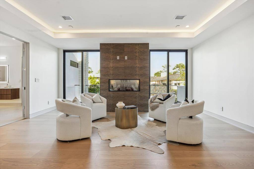 Primary bedroom sitting area with gas fireplace with tile surround and two sliding doors to private balcony