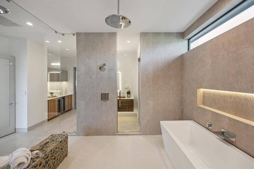Walk in shower with bench seating, soaking tub, multiple shower heads, including LED lit rain shower.