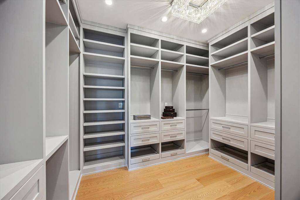 Primary closet #2 with built in drawers, adjustable shelving and hanging space