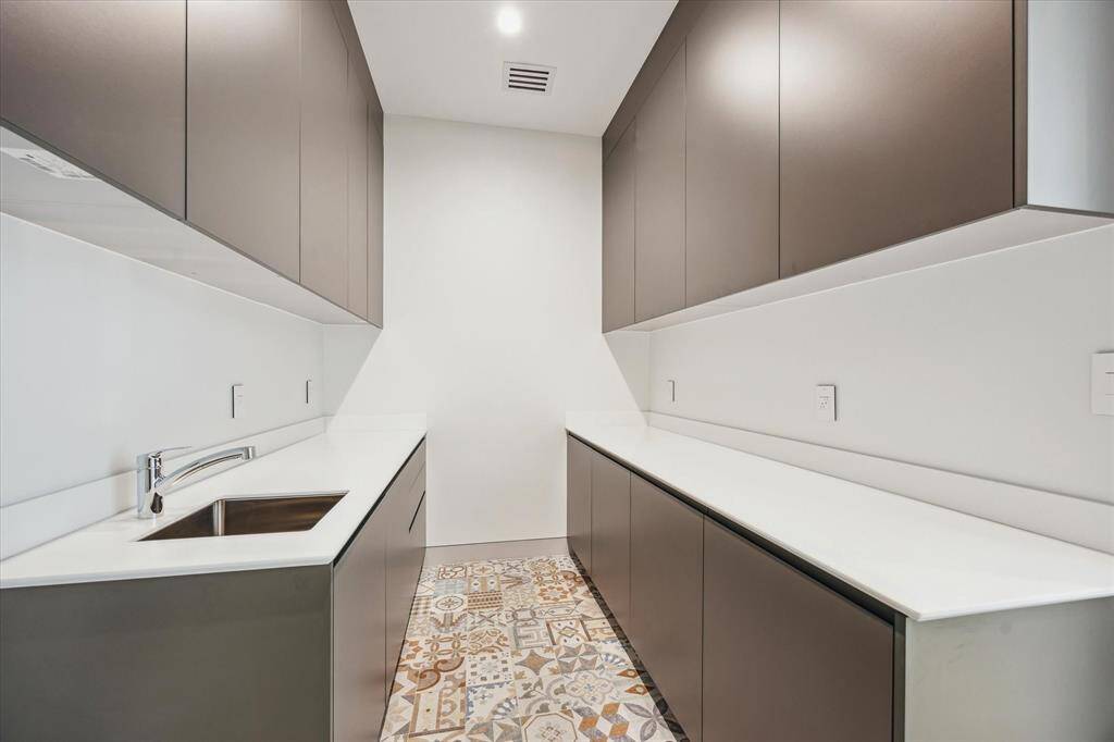 Utility room on level 2 with cabinet storage, sink, and counter space