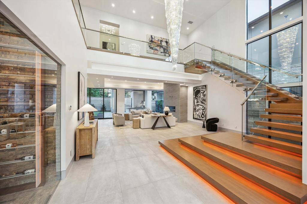 Floating steel frame staircase with glass balustrade, white oak treads, chrome handrail and LED lit steps