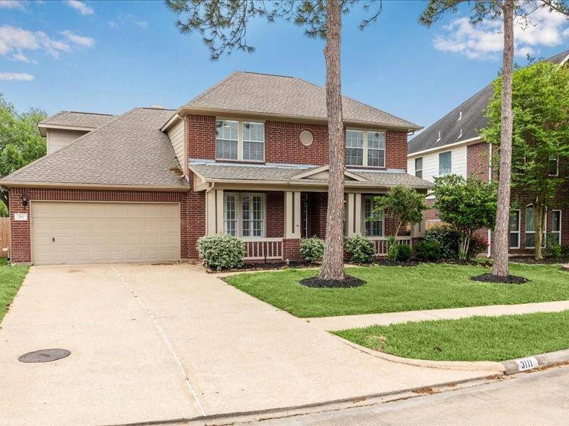 This charming two-story brick home features a spacious two-car garage, a welcoming front porch, and a well-maintained lawn with mature trees. Perfect for family living in a friendly neighborhood.