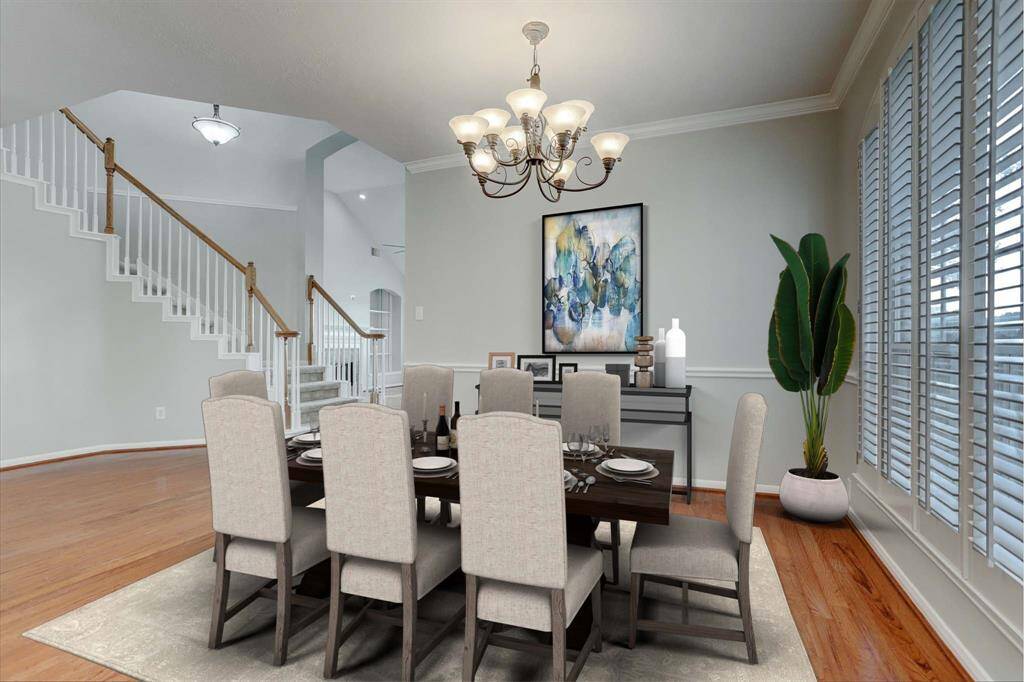 This inviting dining room features  elegant lighting, and abundant natural light from wide windows with blinds, offering a spacious and bright atmosphere.