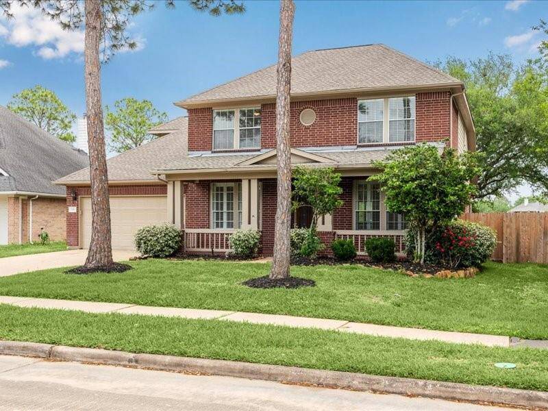 Charming two-story brick home with a welcoming front porch, well-maintained landscaping, and a spacious driveway. Features a fenced backyard, mature trees, and a quiet neighborhood setting. Ideal for family living.