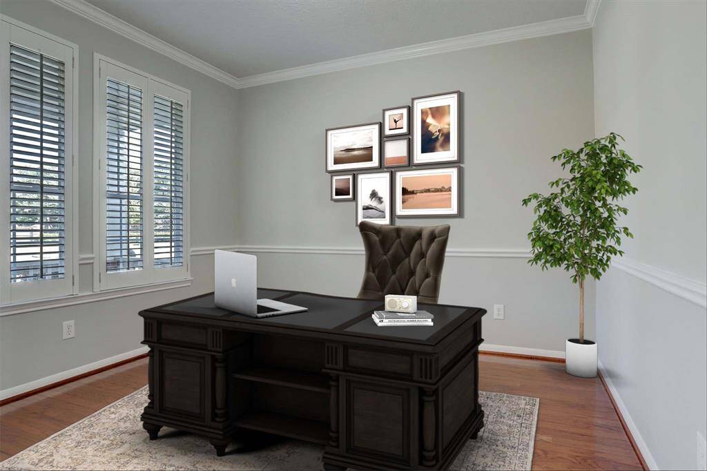 This bright, Office features hardwood floors, light gray walls, and large windows with white shutters, offering a clean and inviting space with ample natural light.