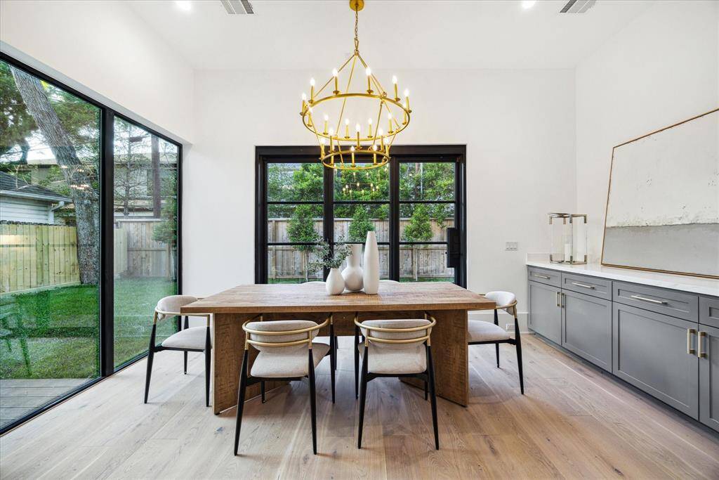 [DINING ROOM] The dining room is a true showstopper, filled with natural light thanks to a dramatic wall of windows and an oversized sliding glass door that seamlessly connects indoor and outdoor living. Designed for both everyday meals and elegant entertaining, this open and airy space captures the essence of modern living with its clean lines, beautiful views, and effortless flow.