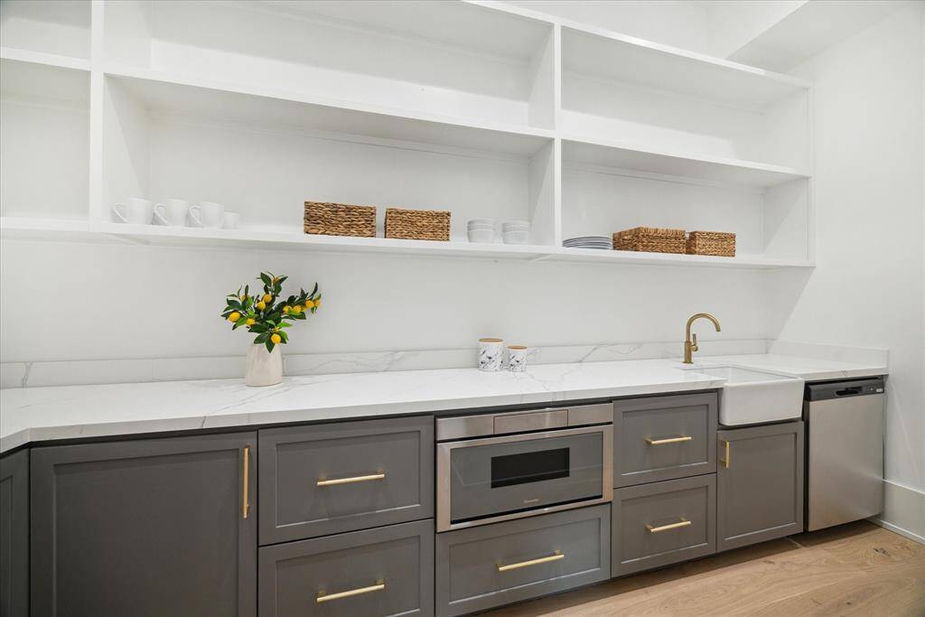 [PANTRY/PREP KITCHEN] Tucked just off the main kitchen, the walk-in pantry and prep kitchen offer the ultimate in functionality and organization. Thoughtfully designed with open shelving, generous counter space, custom cabinetry, a sink, microwave, and a SECOND DISHWASHER, this space is perfect for behind-the-scenes meal prep and effortless entertaining. Whether you're hosting a large gathering or simply keeping the main kitchen clutter-free, this well-equipped secondary kitchen is a true game-changer.