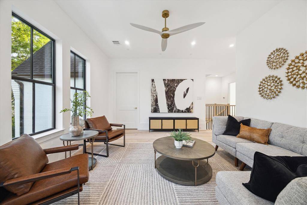 Large windows fill the space with natural light, enhancing its airy feel and creating a perfect setting for gatherings, movie nights, or a cozy retreat.