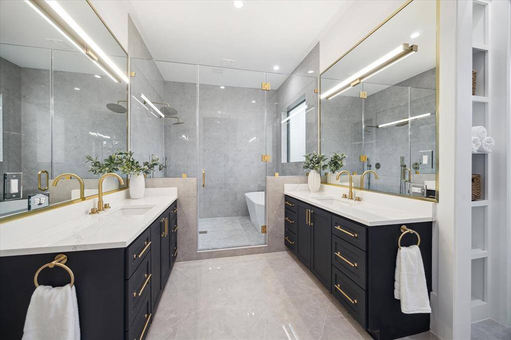 [PRIMARY BATHROOM] Indulge in the serene luxury of the primary bathroom, where designer finishes and thoughtful details create a spa-like retreat. Dual vanities offer comfort and ease for daily routines, while elegant fixtures, sleek surfaces, and custom cabinetry elevate the space. Every element is curated for both function and beauty—making this bathroom a true extension of the primary suite’s sophistication.