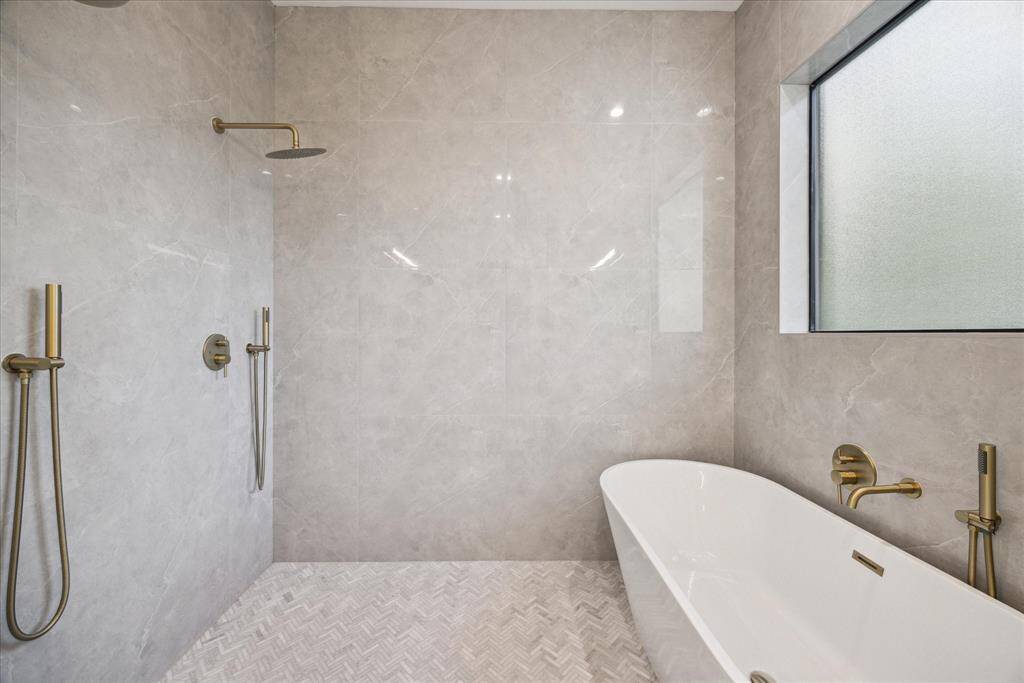 [WET ROOM] Step into a spa-inspired primary bathroom adorned with designer finishes and timeless elegance. At its heart is a stunning wet room featuring a spacious walk-in shower and a freestanding soaking tub—perfect for melting away stress in the most indulgent way. Every detail, from the custom tile-work to the sleek fixtures, is thoughtfully curated to create a sanctuary of comfort and style.