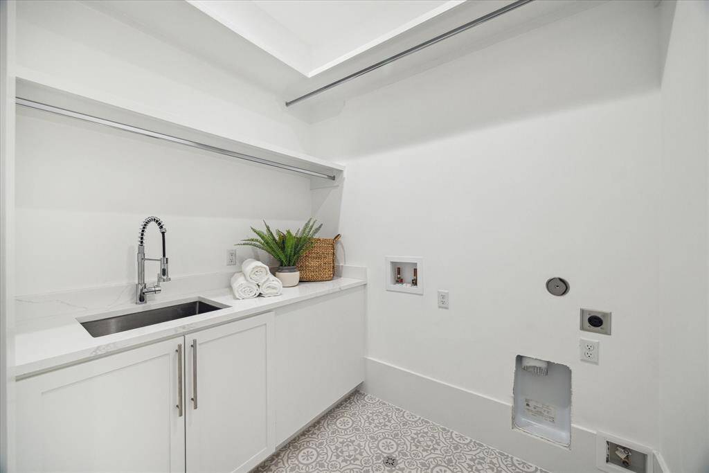[UTILITY ROOM] Designed with both elegance and function in mind, the utility room features chic tile flooring, sleek countertops, a deep utility sink, and dedicated hanging space for laundry care. Whether you're tackling daily chores or organizing with ease, this beautifully finished space turns a routine task into a refined experience.