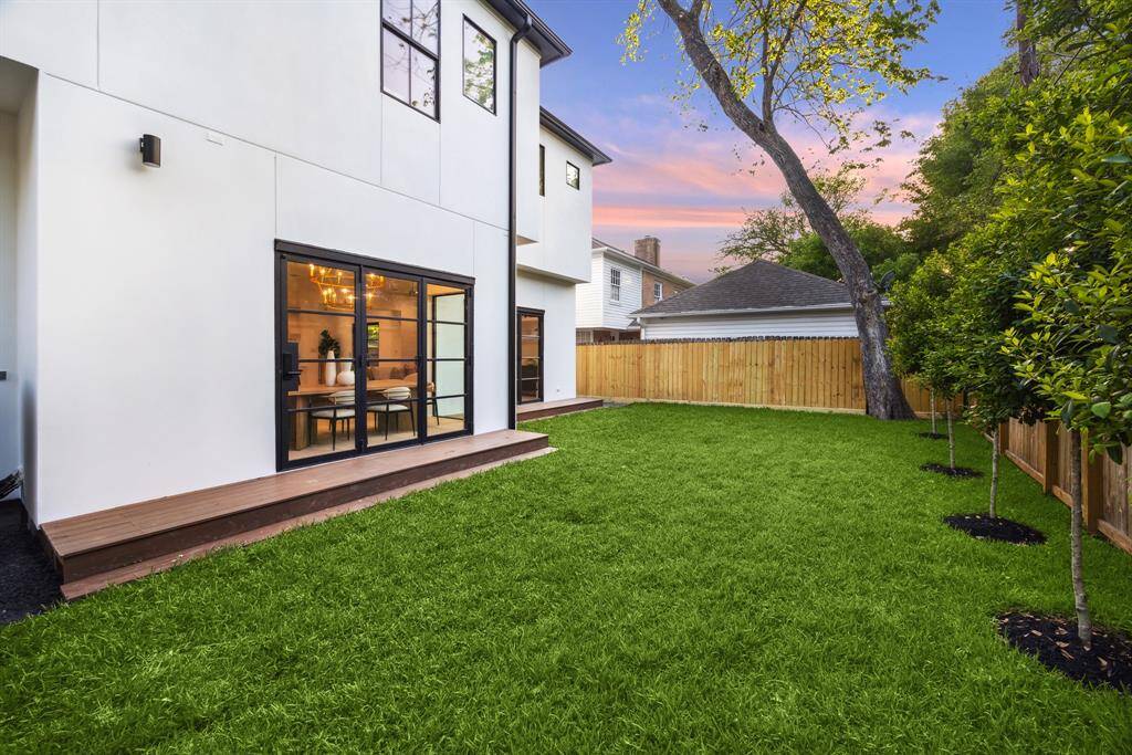 [REAR ELEVATION] The rear elevation of this modern masterpiece is nothing short of breathtaking—anchored by expansive glass doors and walls of windows that showcase the lush, tree-lined backyard beyond. Thoughtfully designed to maximize natural light and serene views, this seamless connection between architecture and nature creates a striking backdrop to everyday living.