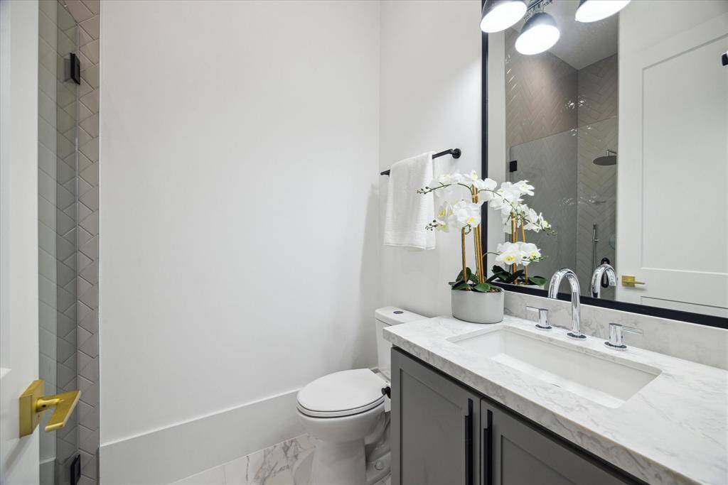[FULL BATH 1ST FLR] Adjacent to the study/guest suite, the first-floor full bathroom is both stylish and functional, featuring a sleek walk-in shower with modern tilework and upscale fixtures