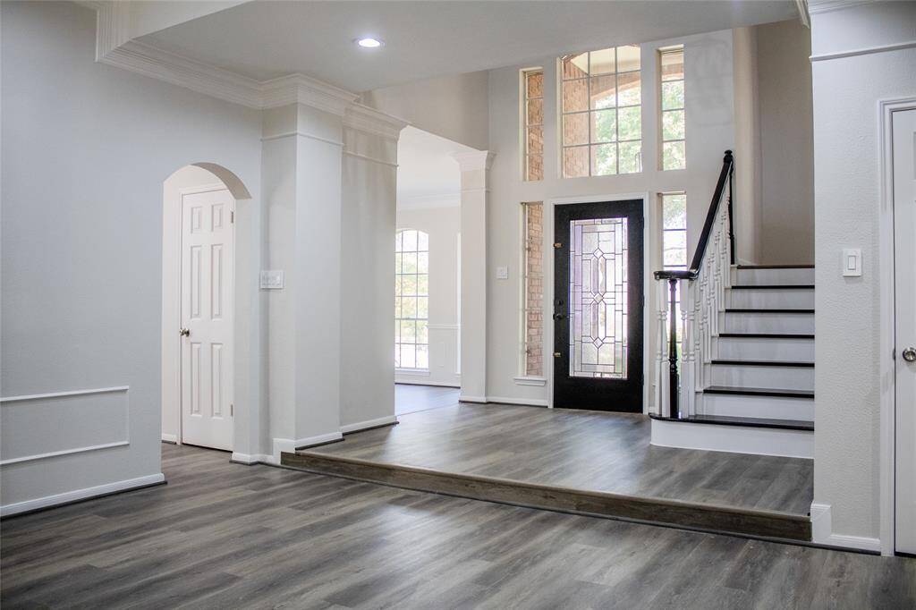 spacious, freshly painted foyer featuring soaring ceilings, updated recessed lighting, and beautiful new flooring
