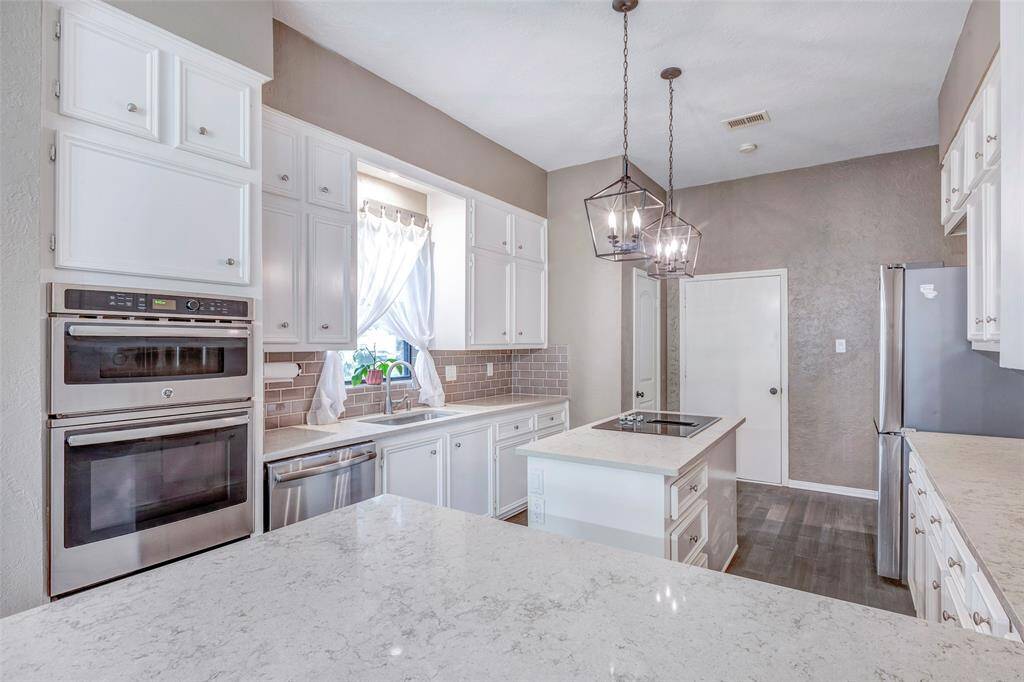 Island cooking, single oven and microwave stainless appliances.