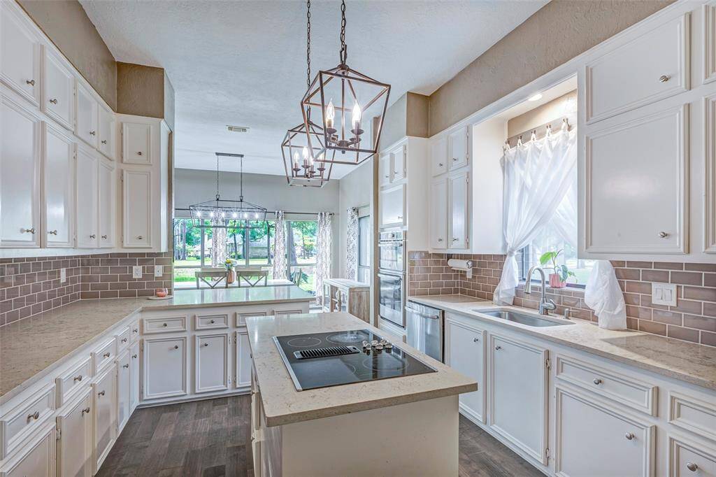 Tiled backsplash, updated counter tops and beautiful designer lighting finish off this kitchen.