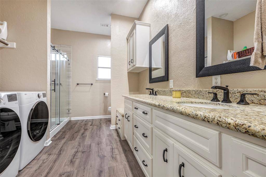 Updated Primary bath- with a Second set of laundry!  Yes, do your laundry in your suite. Primary bath has tiled oversized walk-in shower replaced in 2024.