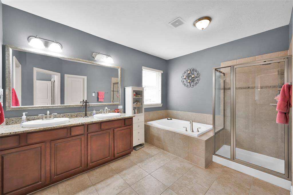 The primary bath has dual sinks and a separate shower and large garden tub.