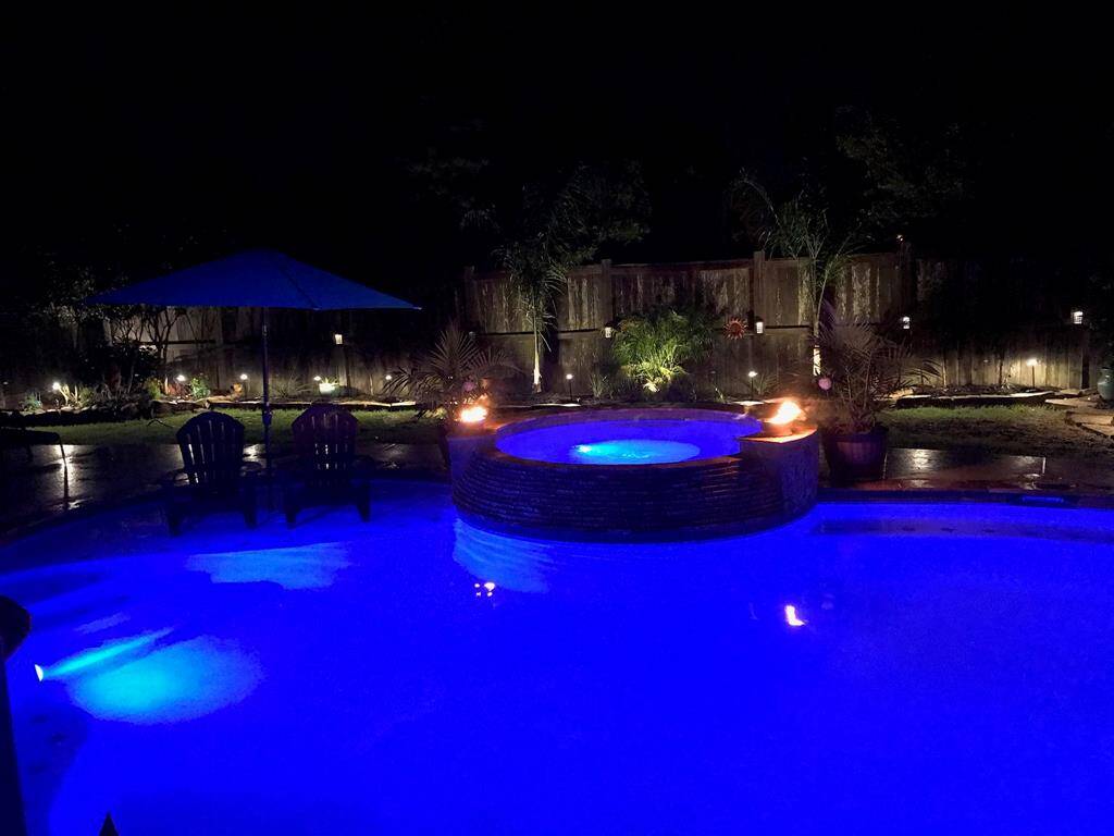 The pool features multi colored lighting and landscape lights.