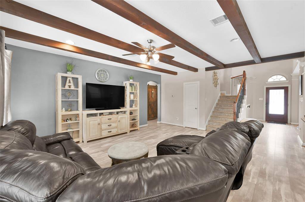 The large family room has wood beam ceilings and a large storage closet under the stairs.