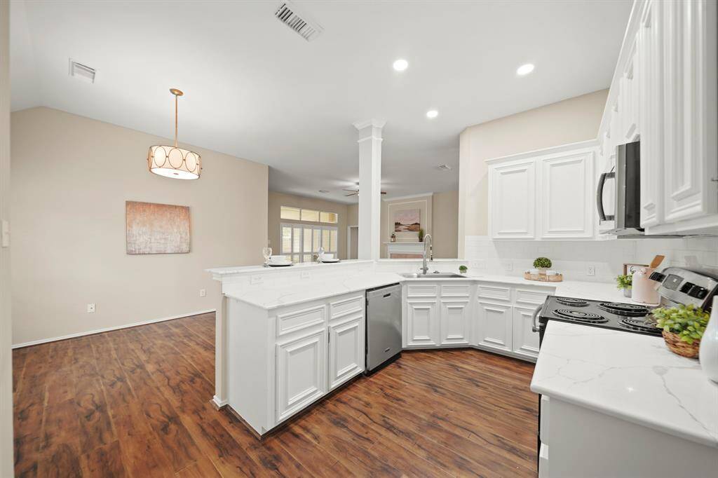 New recessed lighting in the kitchen, cabinets freshly painted, new backsplash and counters.