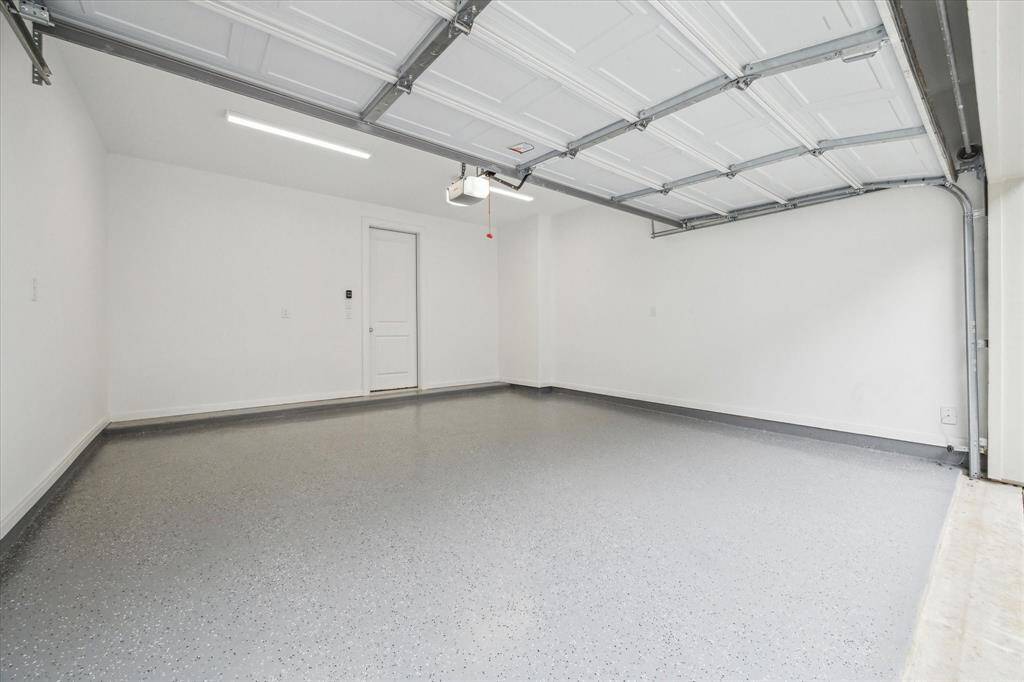 This well-appointed 2-car garage offers both functionality and durability, featuring a sleek epoxy-coated floor that enhances its aesthetic appeal while providing a tough, stain-resistant surface.