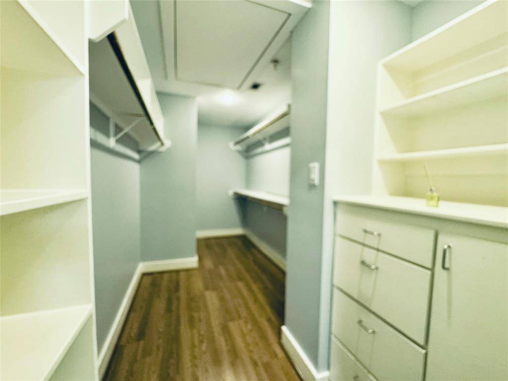 Large walk in closet with built in cabinets and drawers.