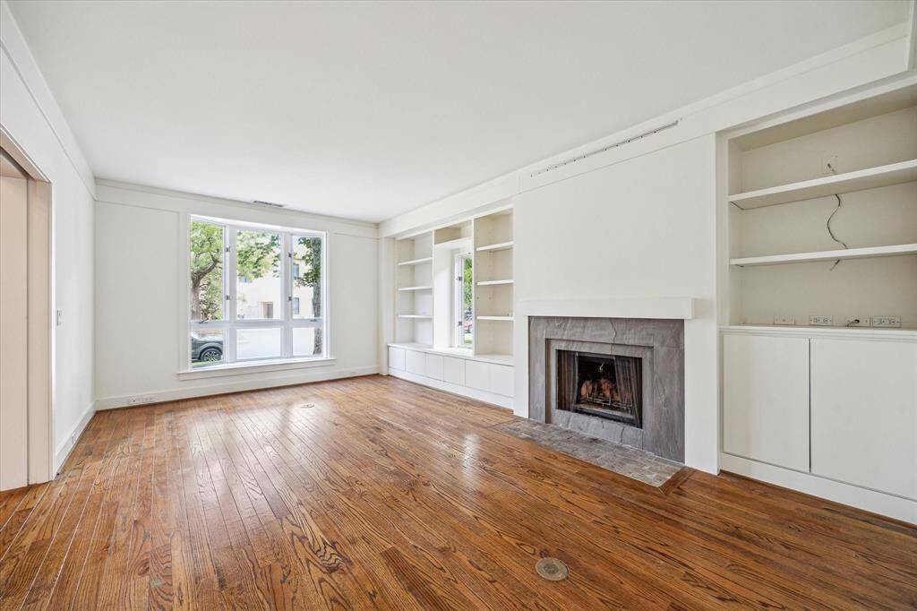Den with shelving and additional fireplace