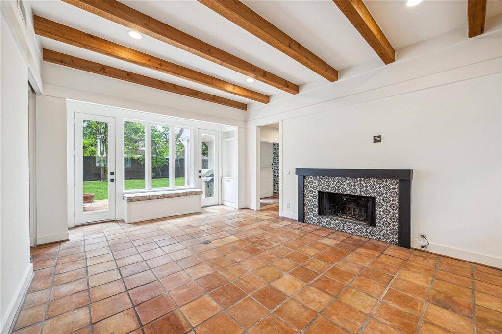 Family room with beamed ceiling houses yet another fiereplace