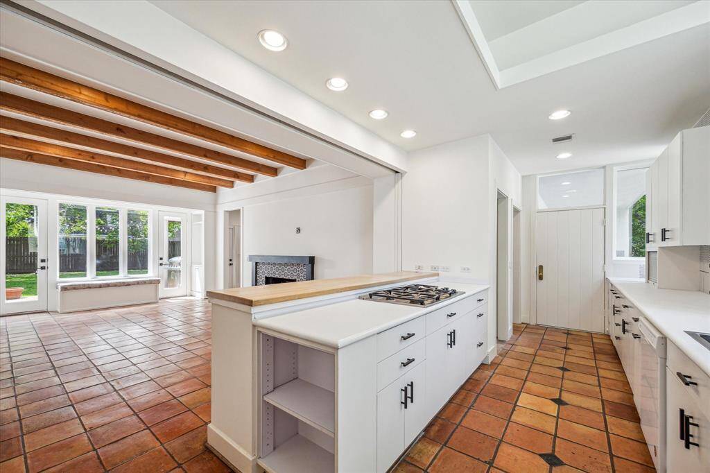Galley kitchen full of light has a butcher block breakfast bar