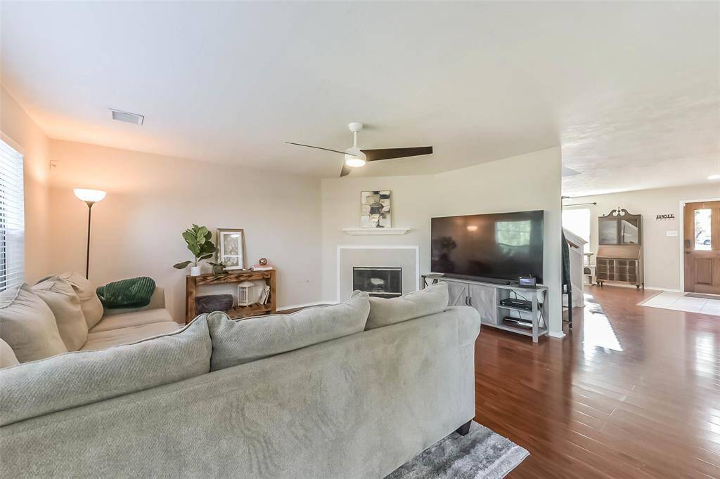 This inviting space flows beautifully from front door to fireplace, with rich wood flooring and clean sightlines throughout. Whether you're hosting or relaxing, this layout just works.