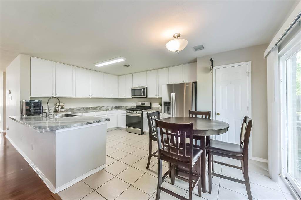 Bright, clean, and ready to cook! This spacious kitchen features sleek stainless steel appliances, updated marble-look countertops, and crisp white cabinetry that keeps everything feeling light and fresh.