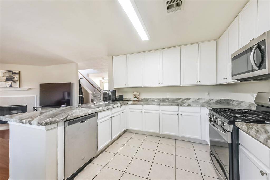 Form meets function in this thoughtfully laid-out kitchen. Loads of cabinet storage, modern fixtures, and clean tile floors make this space both beautiful and practical.