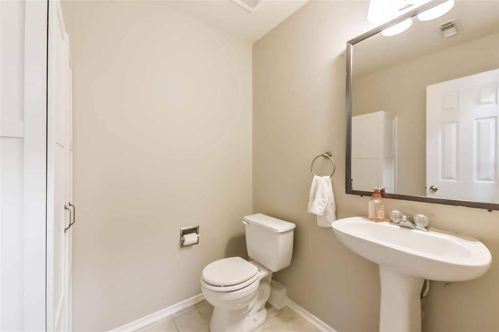Convenient and tucked away, this hallway half bath is ideally located between the living spaces and primary suite—perfect for guests and everyday use. Neutral tones and a pedestal sink keep it feeling fresh and uncluttered.