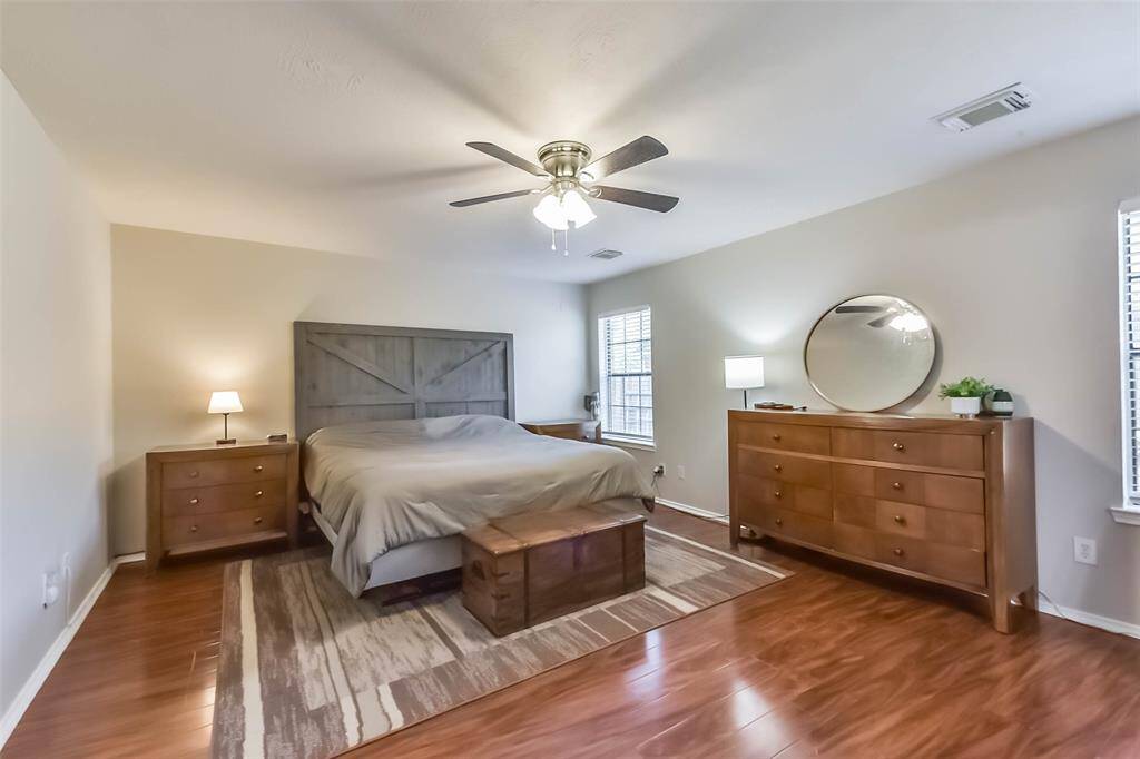 Your peaceful retreat awaits. This oversized primary suite features warm wood floors, soft natural light, and space for a full furniture set—with plenty of room to spare.